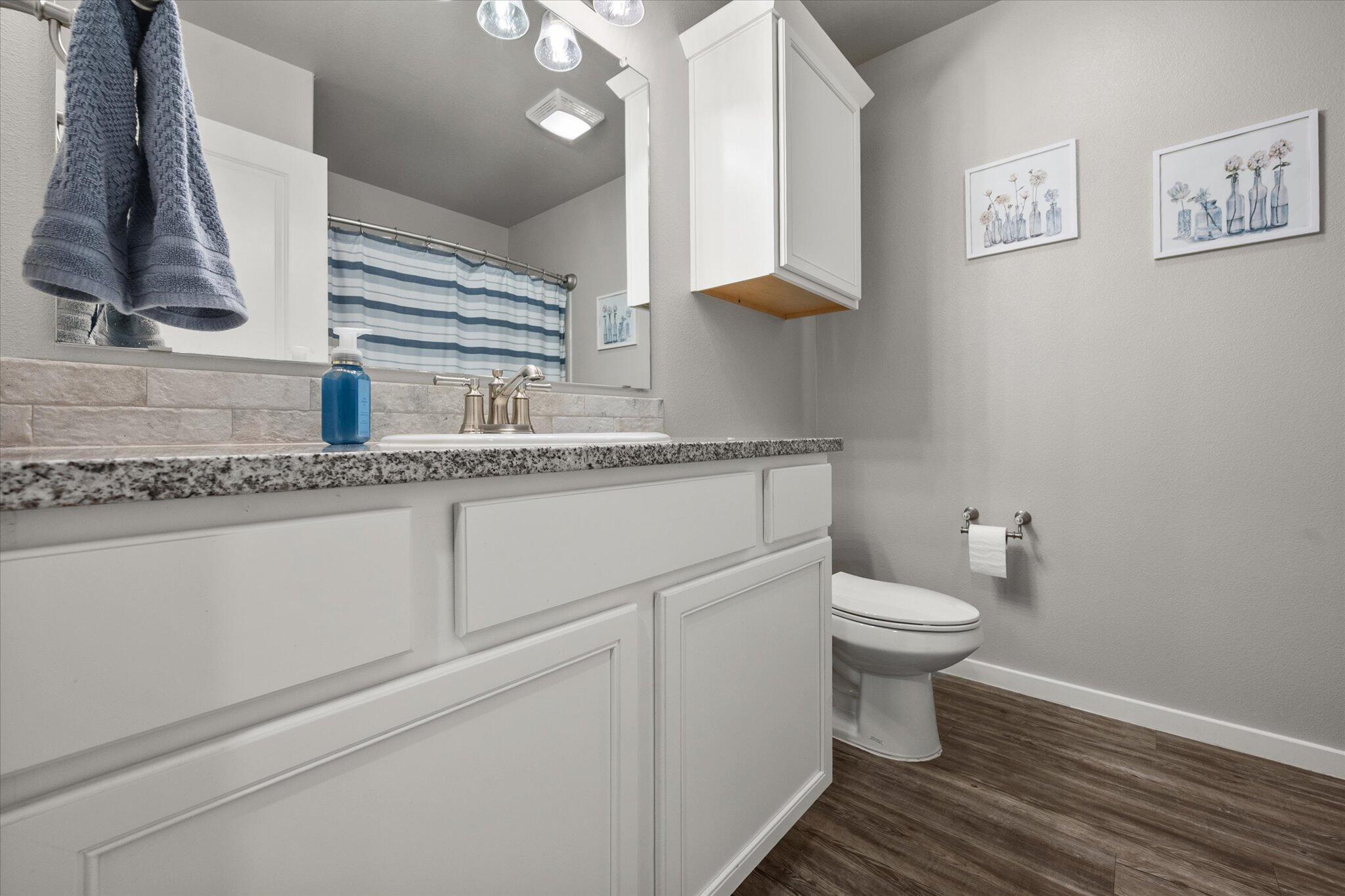 2010 142nd Street Lubbock, TX 79423 - Photo 8 of 33 a bathroom with a granite countertop toilet and a sink