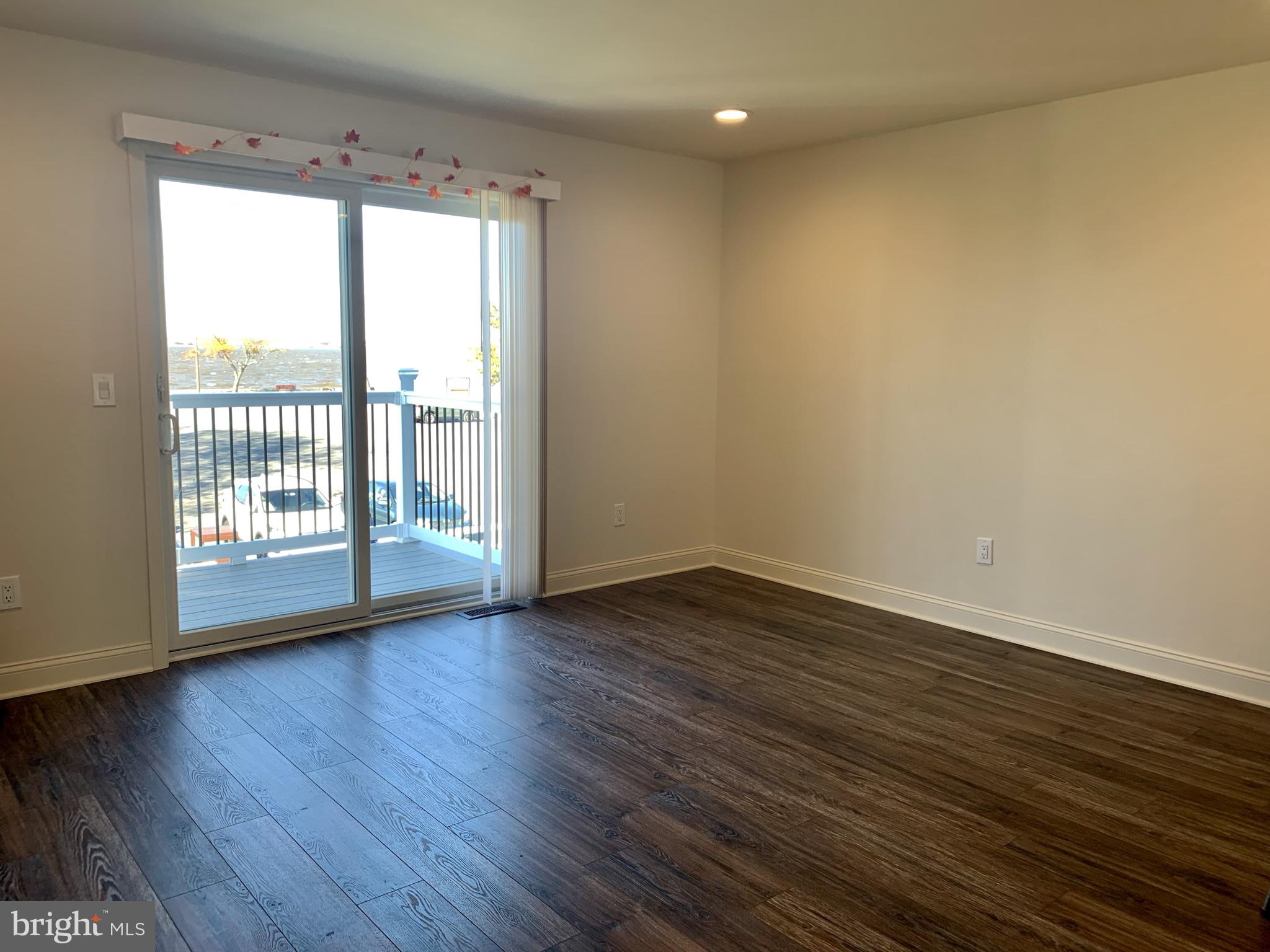 46 West Pittsfield Street Pennsville, NJ 08070 - Photo 3 of 25 a view of an empty room with wooden floor and a window