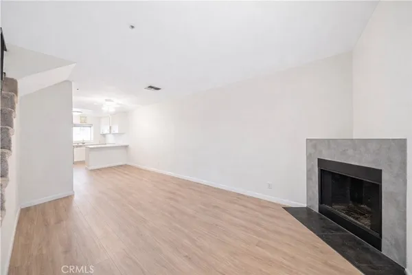 a view of empty room with wooden floor and fireplace