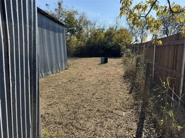 a view of a yard with wooden fence