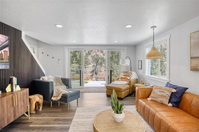a living room with furniture fireplace and large windows