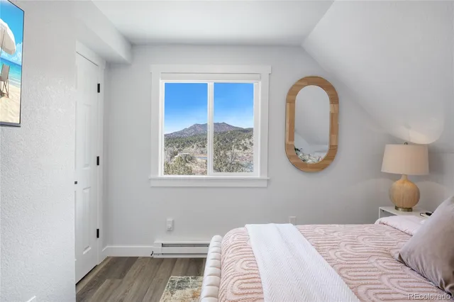 a bedroom with a bed and a painting on the wall