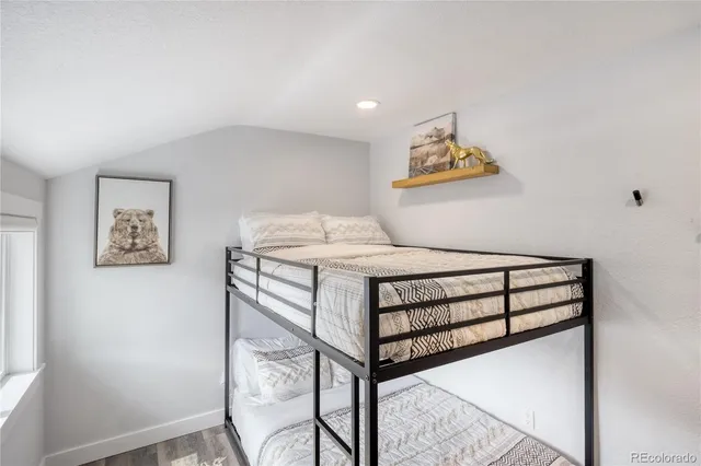 a bedroom with a bed and painting on the wall