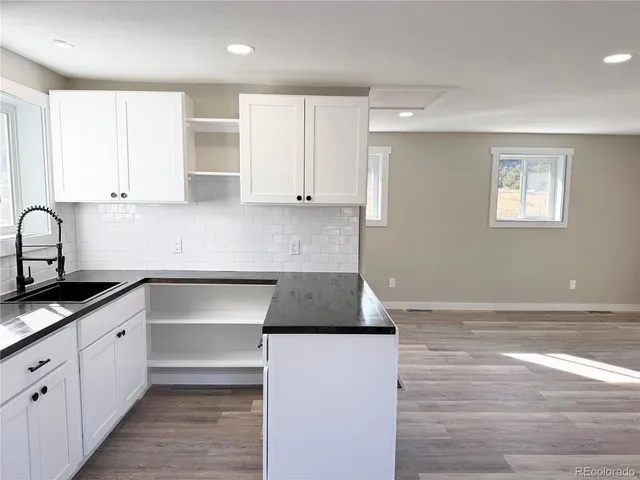 a kitchen with granite countertop a sink and cabinets