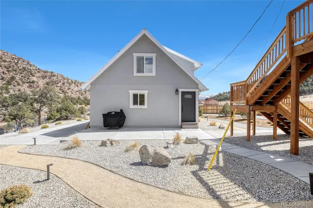 a view of a house with backyard and sitting area