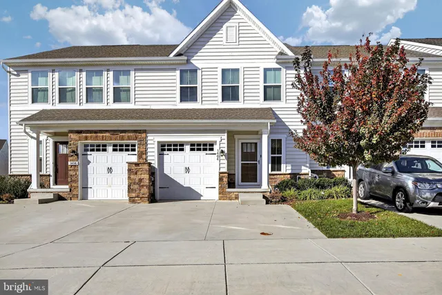 a living room with furniture a clock on wall and a window