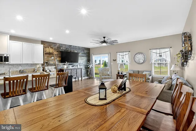 a kitchen with stainless steel appliances kitchen island granite countertop a stove top oven a sink a dining table and chairs