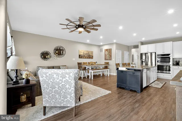 a kitchen with stainless steel appliances a dining table chairs microwave and sink