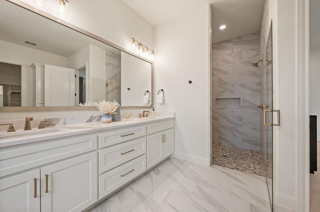 3006 Wheeler Branch Road Granbury, TX 76049 - Photo 20 of 29 Spacious bathroom featuring a dual vanity with white cabinetry, a large frameless mirror, and brass hardware