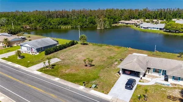an aerial view of residential houses with outdoor space and lake view