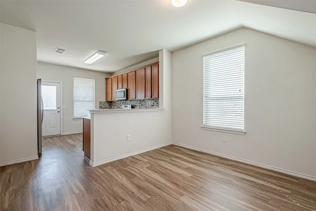 a view of a kitchen with wooden floor and a window