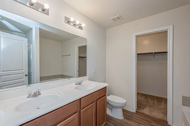 a bathroom with a toilet a sink and mirror