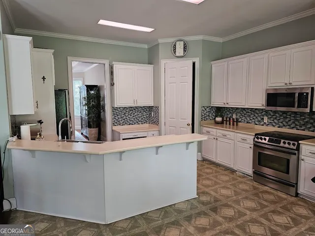 a kitchen with stainless steel appliances a stove sink and cabinets