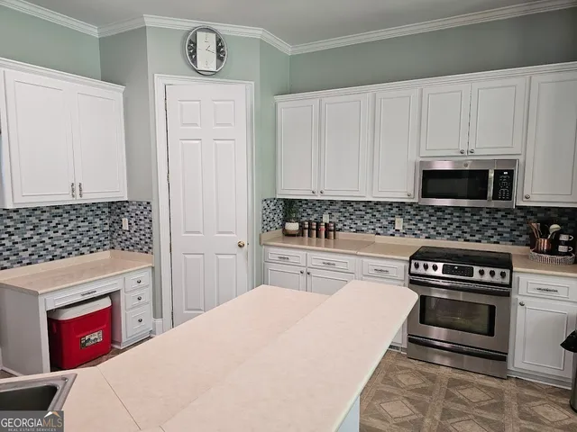 a kitchen with a stove and white cabinets