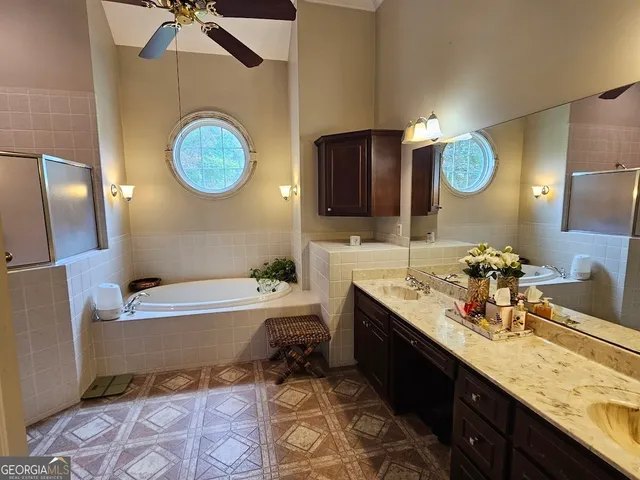 a bathroom with a granite countertop sink mirror vanity and bathtub