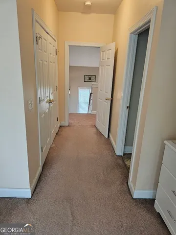 a view of a hallway with closet and cabinet