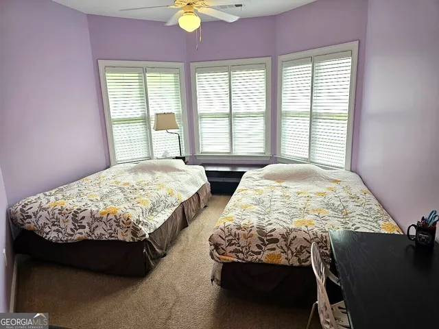a bedroom with two beds chair and a window
