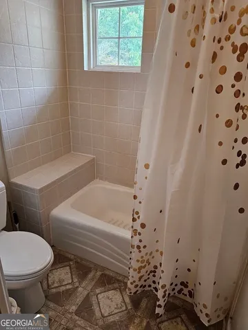 a white toilet sitting next to a bath tub