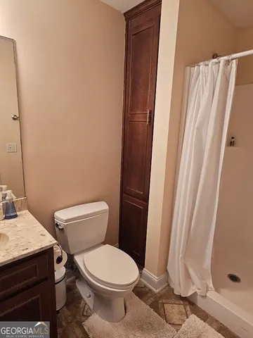 a white toilet sitting next to a shower curtain