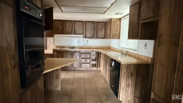 a kitchen with kitchen island granite countertop a sink stove and refrigerator