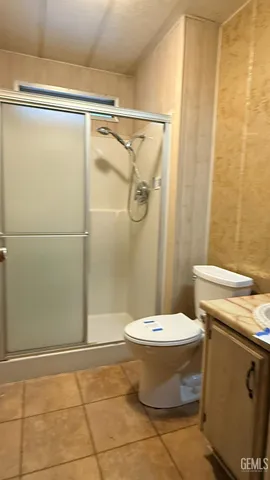 a bathroom with a granite countertop shower toilet and sink