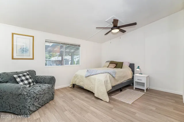 a spacious bedroom with a bed couch and window