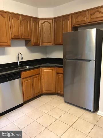 a kitchen with a refrigerator sink and cabinets