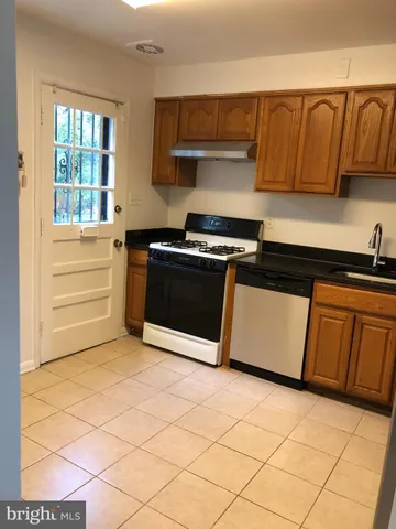 a kitchen with granite countertop a sink and a stove top oven