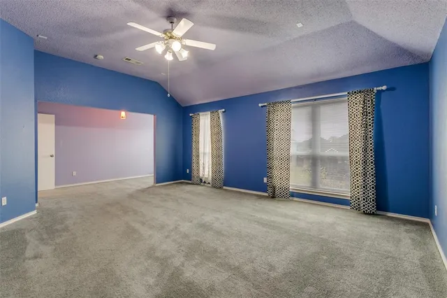 a view of a livingroom with a chandelier fan and windows