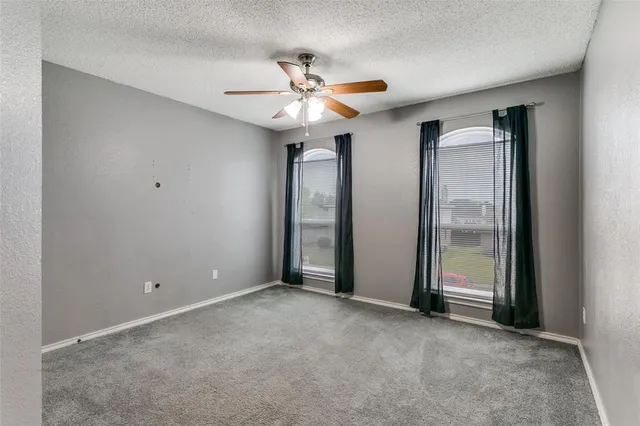 a view of an empty room with a ceiling fan
