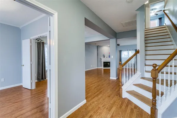 a view of a hallway with wooden floor and staircase