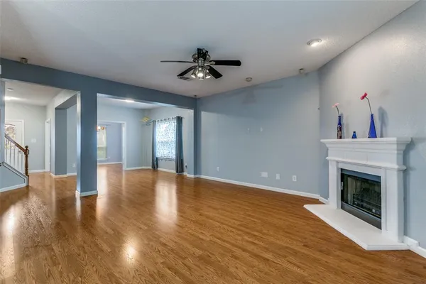a view of empty room with wooden floor and fireplace