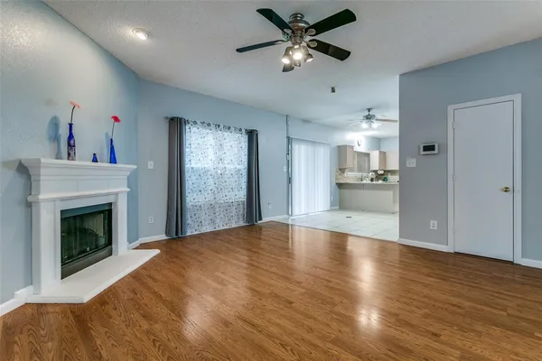 a view of empty room with wooden floor and fireplace