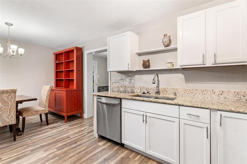 398 Rose Street Umatilla, FL 32784 - Photo 13 of 30 a kitchen with granite countertop a sink cabinets stainless steel appliances and a wooden floor