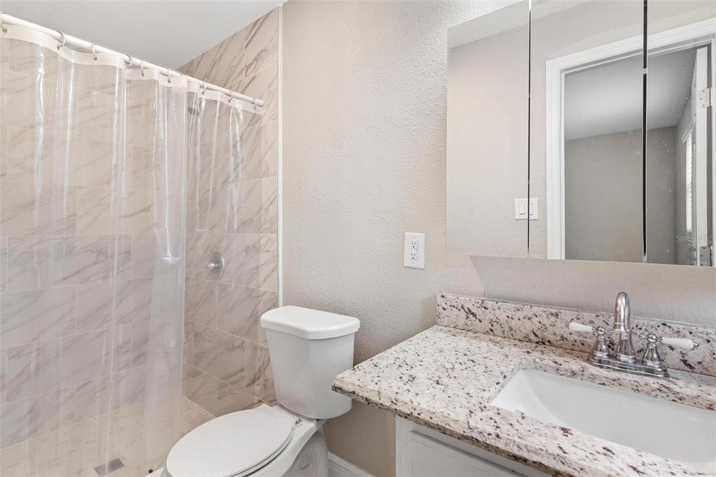 398 Rose Street Umatilla, FL 32784 - Photo 16 of 30 a bathroom with a granite countertop sink toilet and shower