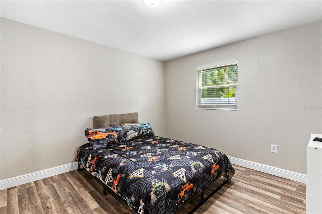 398 Rose Street Umatilla, FL 32784 - Photo 17 of 30 a bed sitting in a bedroom next to a window