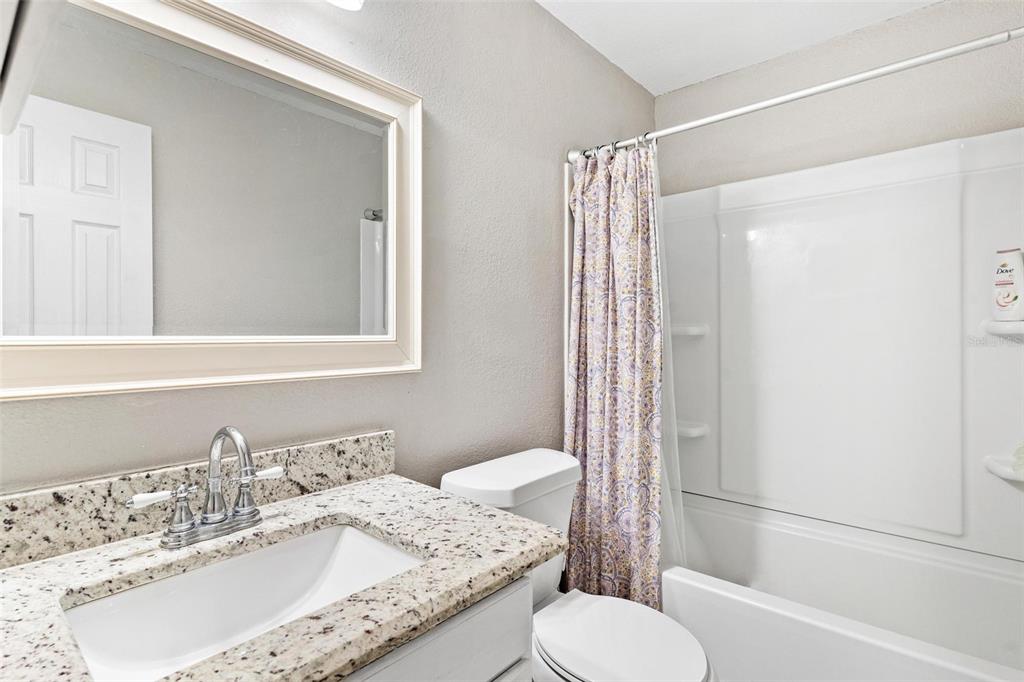 398 Rose Street Umatilla, FL 32784 - Photo 20 of 30 a bathroom with a granite countertop sink toilet and shower