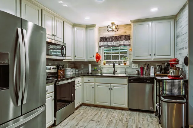 a kitchen with stainless steel appliances a refrigerator sink and cabinets