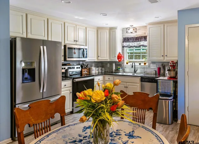 a kitchen with stainless steel appliances granite countertop a refrigerator and a stove top oven