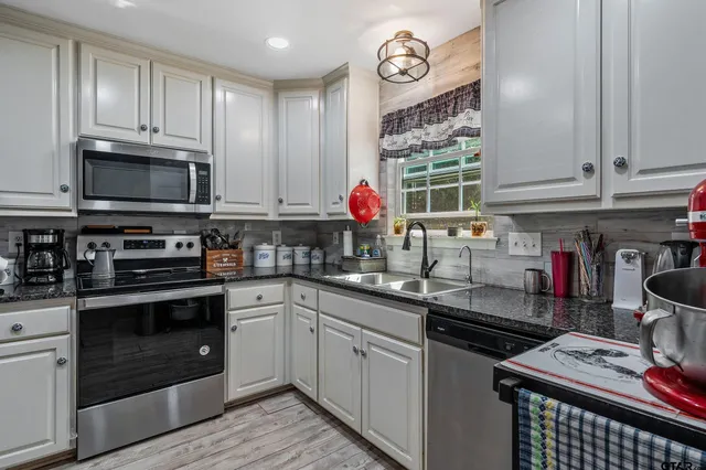 a kitchen with stainless steel appliances granite countertop a stove and cabinets