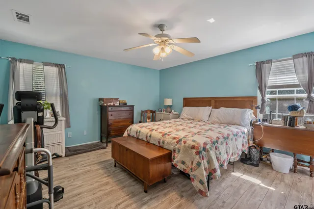 a bedroom with bed and wooden floor
