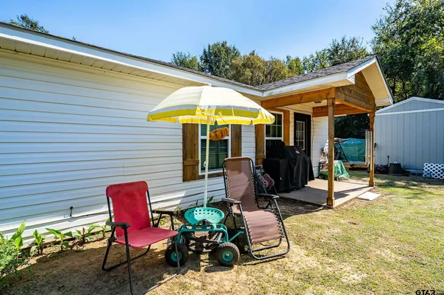 a view of a patio with table and chairs under an umbrella
