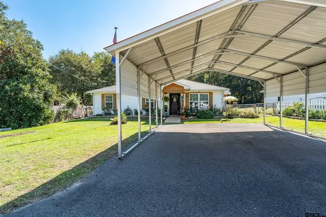 a view of swimming pool with lawn chairs under an umbrella