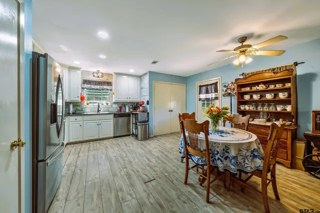 a kitchen with stainless steel appliances a table chairs and a refrigerator