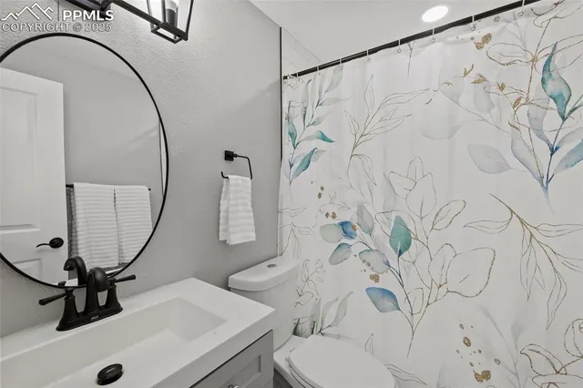 a bathroom with a sink vanity mirror and toilet