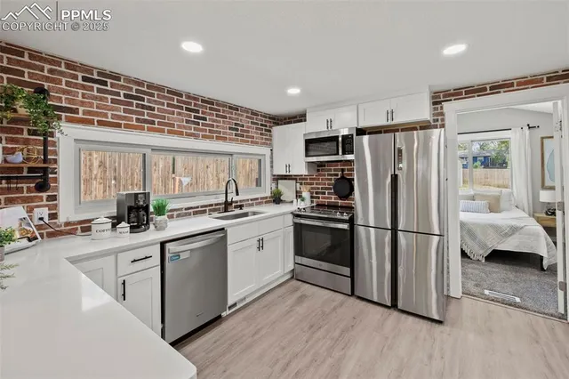 a kitchen with a refrigerator a sink and cabinets