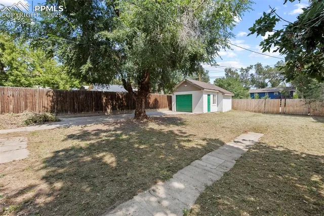 a view of a yard with a house and large tree