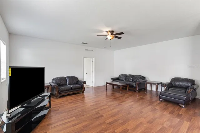 a living room with furniture and a wooden floor