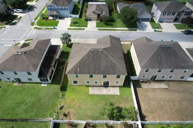 an aerial view of a city with lots of residential buildings and mountain view in back