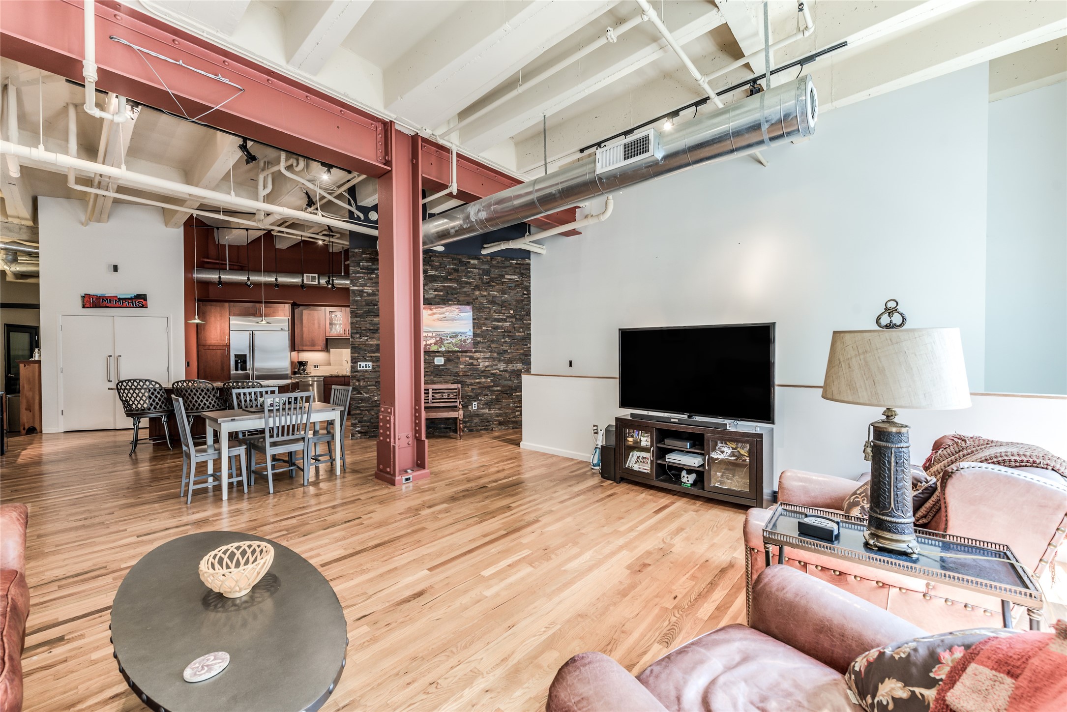 705 Main Street, Unit 215 Houston, TX 77002 - Photo 9 of 36 This open-concept loft features high ceilings with exposed beams and ductwork, hardwood floors, and a mix of industrial and rustic elements.